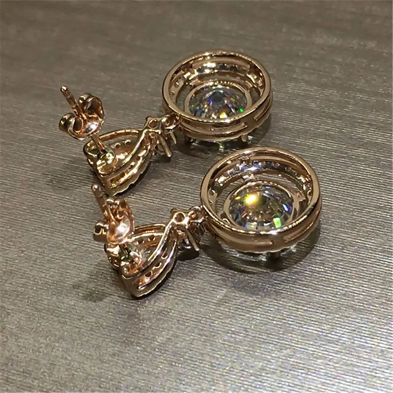 1. gioielli - orecchini pendenti color oro rosa con zirconi
